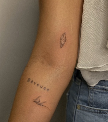 Fine line tattoos on an arm covering a scar